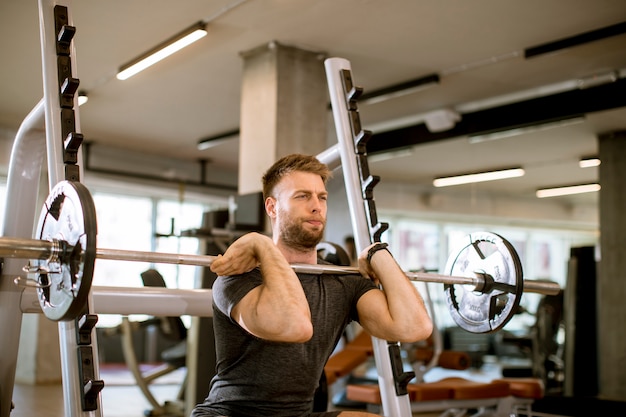 Joven trabajando con pesas en el gimnasio