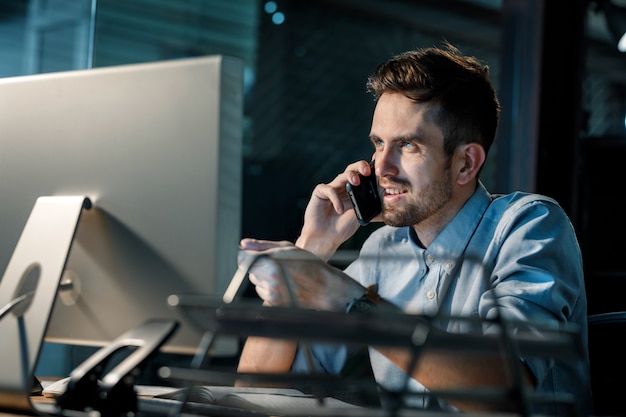 Joven trabajando hasta tarde en la oficina