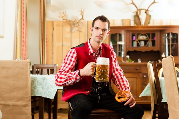 Joven en Tracht tradicional bávara en restaurante o pub