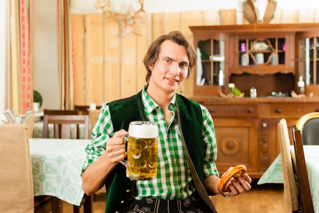 Joven en Tracht tradicional bávara en restaurante o pub