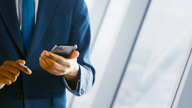 Joven en traje usando un teléfono inteligente en la oficina Concepto de negocio