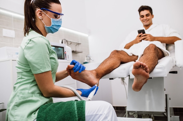 Joven con tratamiento de pedicura en un moderno salón de belleza.