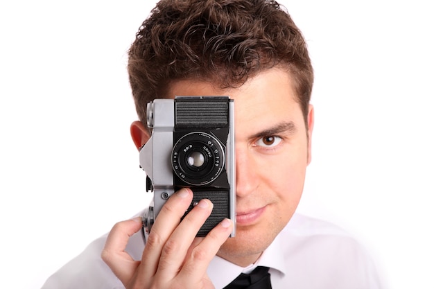 Un joven tratando de tomar una foto contra el fondo blanco.