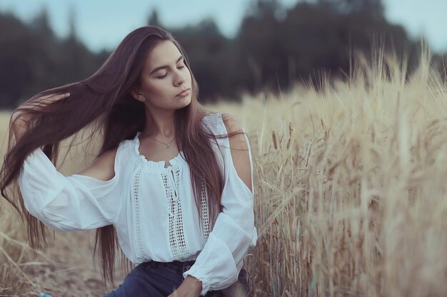 Una joven triste y solitaria en un campo aburrida por la depresión.