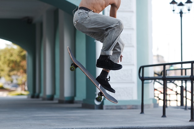 Joven truco de patinaje en patineta en la ciudad