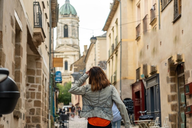 Un joven turista en las casas con entramados de madera medievales en Rennes, capital de Bretaña, Francia