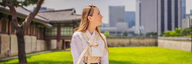 Joven turista caucásica con vestido nacional coreano hanbok Concepto de viaje a Corea Ropa nacional coreana Entretenimiento para turistas probándose ropa nacional coreana BANNER FORMATO LARGO