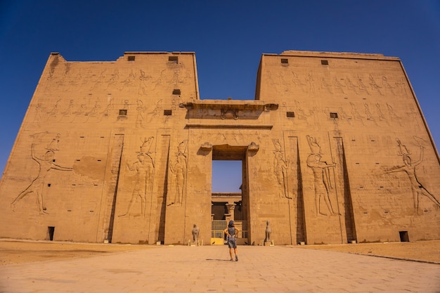 Un joven turista a la entrada del templo de Edfu cerca del río Nilo en Asuán. egipcio