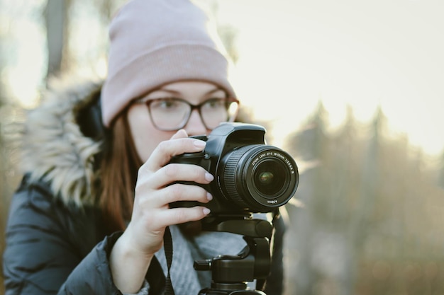 Un joven turista europeo sonríe alegremente mirando la ciudad con una cámara vieja Chica fotógrafa