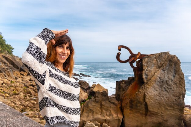 Un joven turista europeo visitando el Peine del Viento en San Sebastián