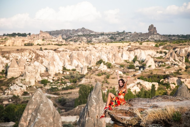 Joven turista feliz viajera con vestido brillante disfrutando de unas vacaciones en el desierto de Capadocia Turquía