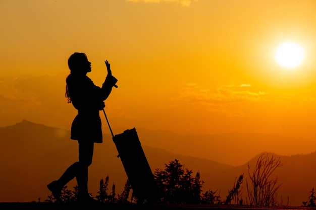 Joven turista llevando equipaje al atardecer