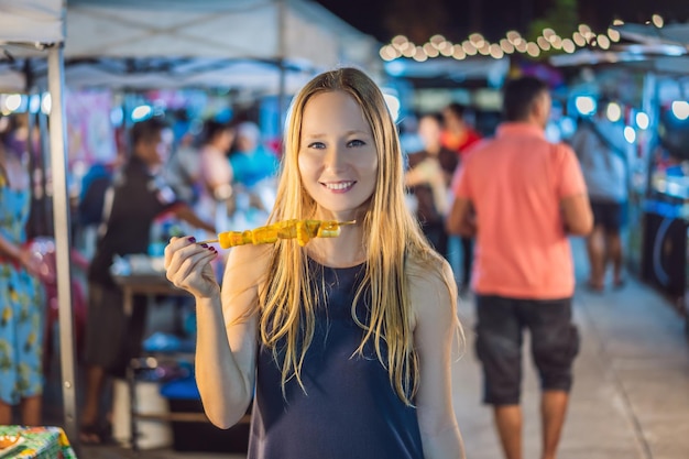 Joven turista en el mercado de comida asiática de Walking Street