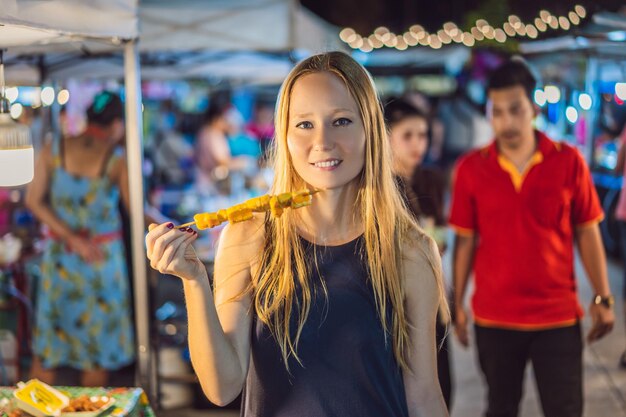 Joven turista en el mercado de comida asiática de Walking Street