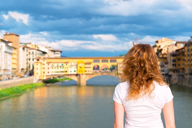 Joven turista mira el Ponte Vecchio en Florencia