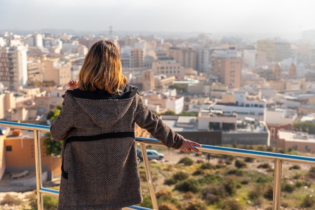 Una joven turista mirando la ciudad desde el mirador del Cerro San Cristóbal en la ciudad de Almería, Andalucía. España. Costa del sol en el mar mediterráneo