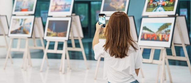 Joven turista mirando exposición de galería Fotografía de arte y concepto de museo
