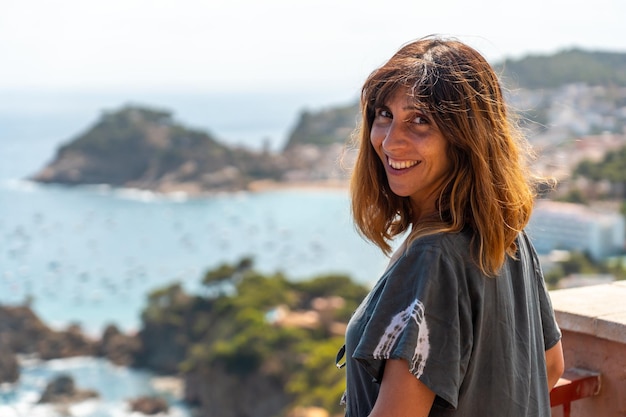 Un joven turista mirando Tossa de Mar desde el mirador Girona en la Costa Brava