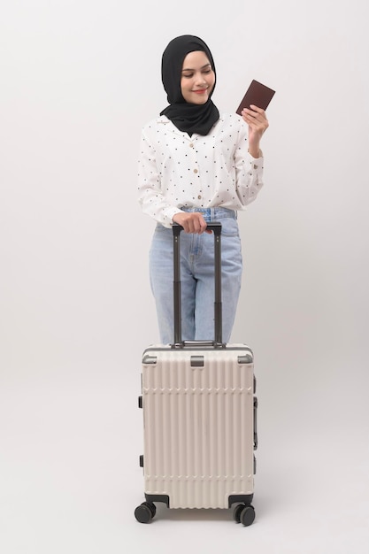 Una joven turista musulmana con equipaje de fondo blanco