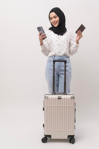 Una joven turista musulmana con equipaje de fondo blanco