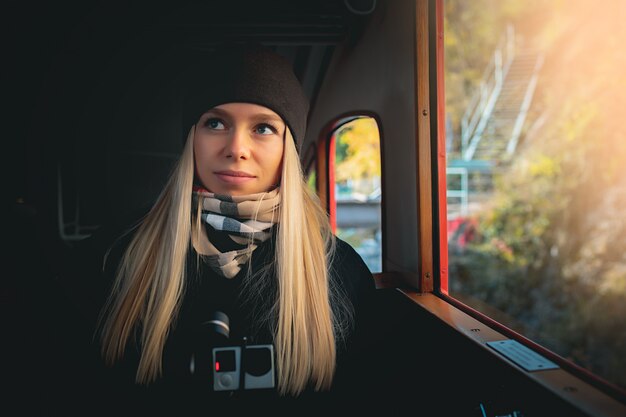 Joven turista rubia hermosa en un tren cerca de la ventana