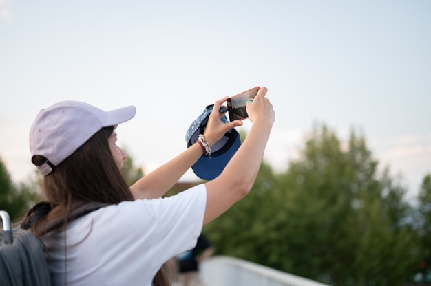 Joven turista tomando fotografías en el teléfono.