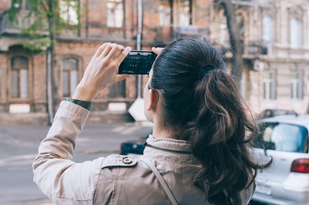 Joven turista tomando fotos de la arquitectura antigua mientras viaja