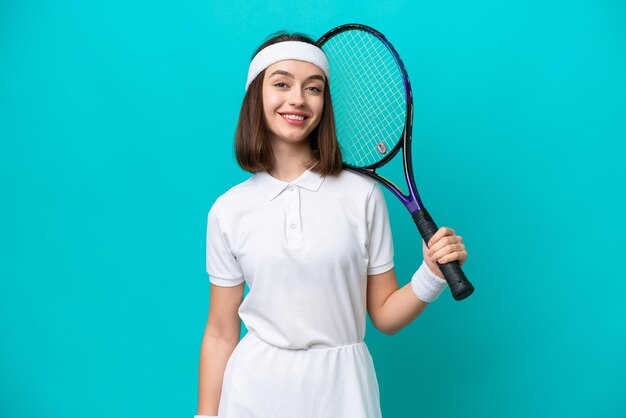 Joven ucraniana aislada de fondo azul jugando al tenis