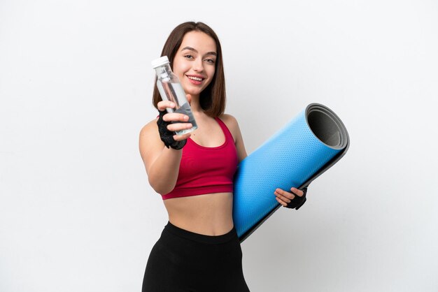 Joven ucraniana aislada de fondo blanco con una botella de agua deportiva y con una alfombra