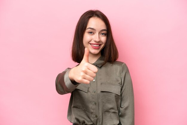 Joven ucraniana aislada de fondo rosa con los pulgares hacia arriba porque algo bueno ha sucedido