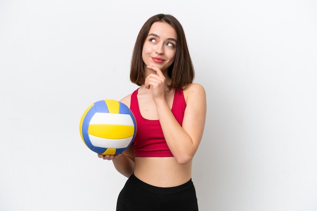 Joven ucraniana jugando voleibol aislada de fondo blanco y mirando hacia arriba