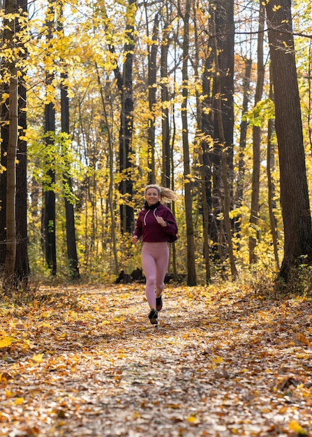 Una joven con uniforme deportivo Deportes Trotar en el parque de otoño Follaje amarillo Estilo de vida activo Humano y naturaleza Estilo de vida saludable Correr