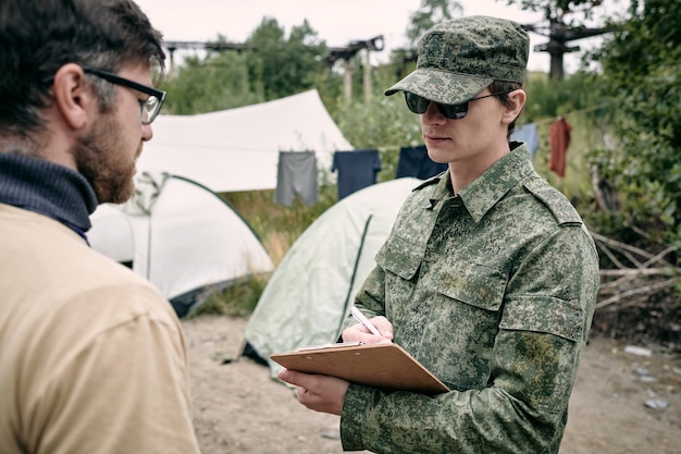 Joven en uniforme mirando el documento en sus manos