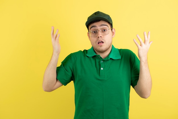 joven en uniforme verde de pie y posando.