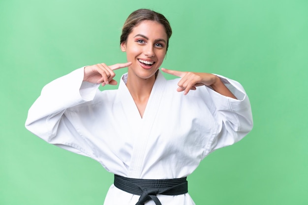 Joven uruguaya haciendo karate sobre un fondo aislado dando un gesto de pulgar hacia arriba