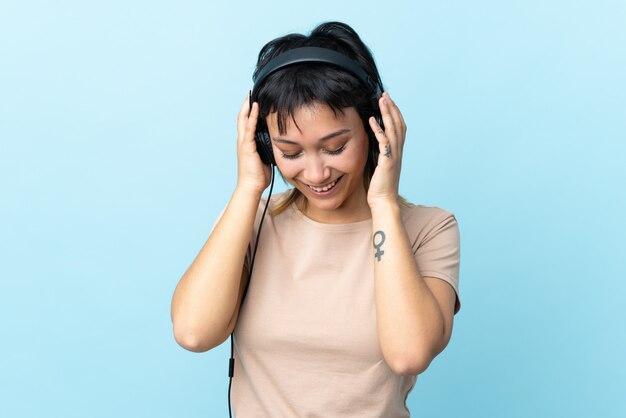 Joven uruguaya sobre aislado azul escuchando música