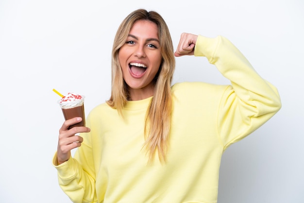 Joven uruguaya sosteniendo Frappuccino aislado de fondo blanco haciendo un gesto fuerte