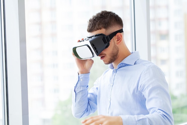Joven usando casco de realidad virtual en exhibición de tecnología