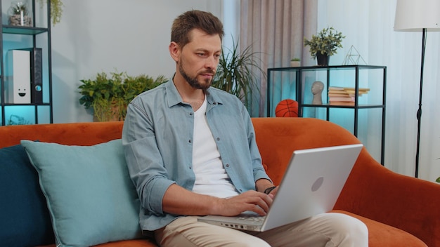 Joven usando una computadora portátil en casa