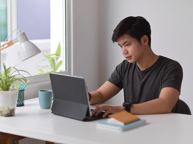 Joven usando una computadora portátil en la mesa