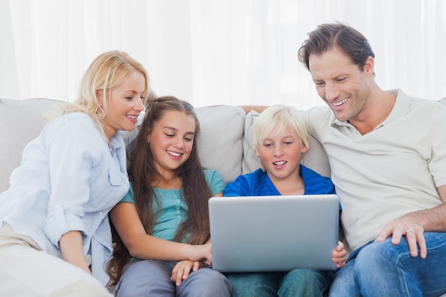 Foto joven usando una computadora portátil con su familia