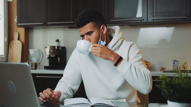 Foto joven usando una computadora portátil en una taza de café