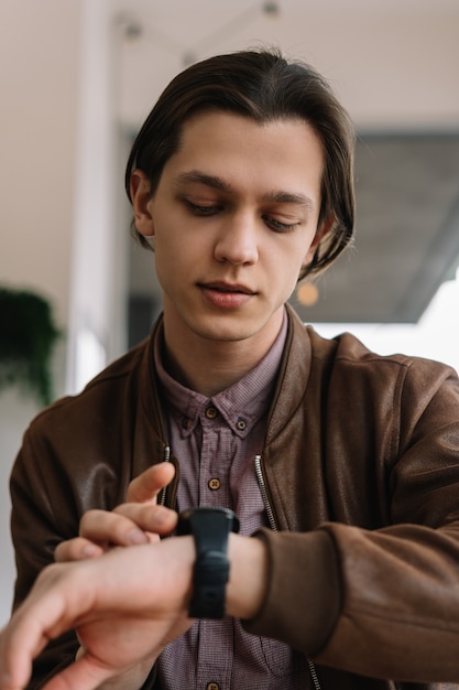 Joven usando reloj inteligente, tocando la pantalla digital