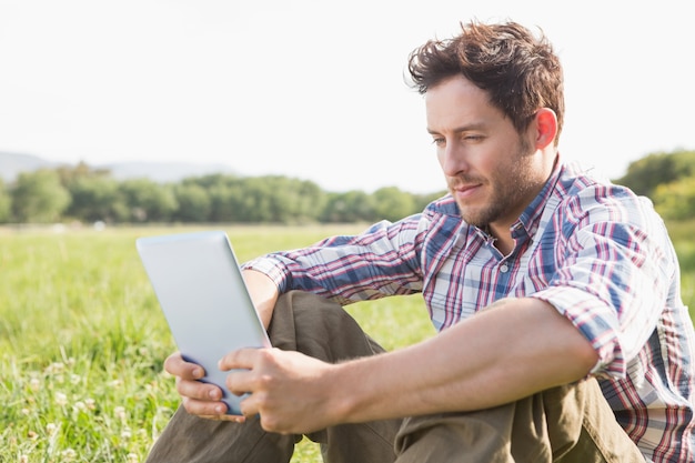 Joven usando tableta en el campo