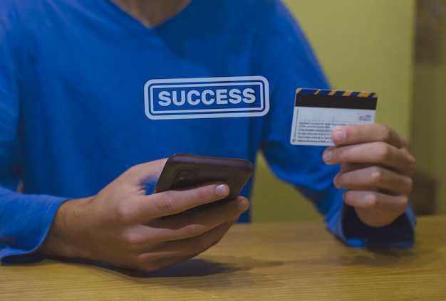 Joven usando tarjeta de crédito con su tarjeta de crédito phosing con su concepto de consumidor de teléfono