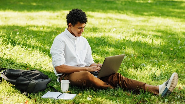 Joven usando el teléfono móvil en el campo