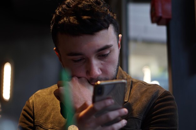 Joven usando el teléfono móvil en casa