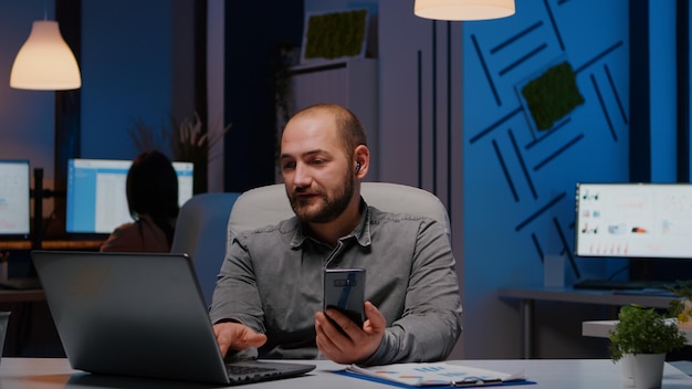 Joven usando el teléfono móvil mientras está sentado en la mesa