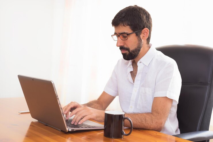 Foto joven usando el teléfono móvil mientras está sentado en la mesa