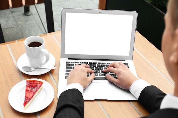 Joven, usar la computadora portátil, en la mesa